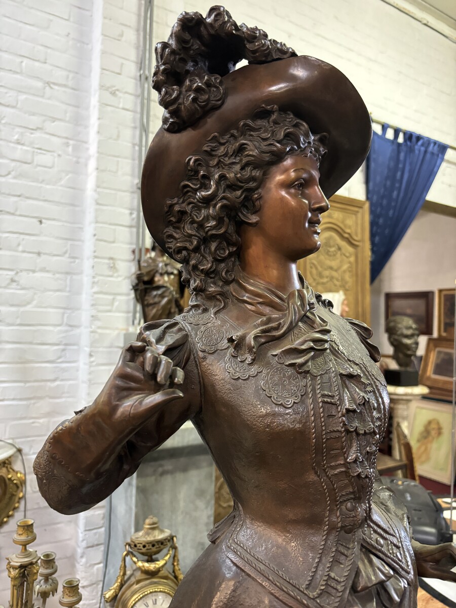 Very large bronze sculpture ‘noble lady ’ 19th century ( 103 cm ). Elegant sculpture of a noble lady with feather hat, signed by Ernest Rancoulet ( French 1870-1915 ). In good condition, with a dent in the base. 