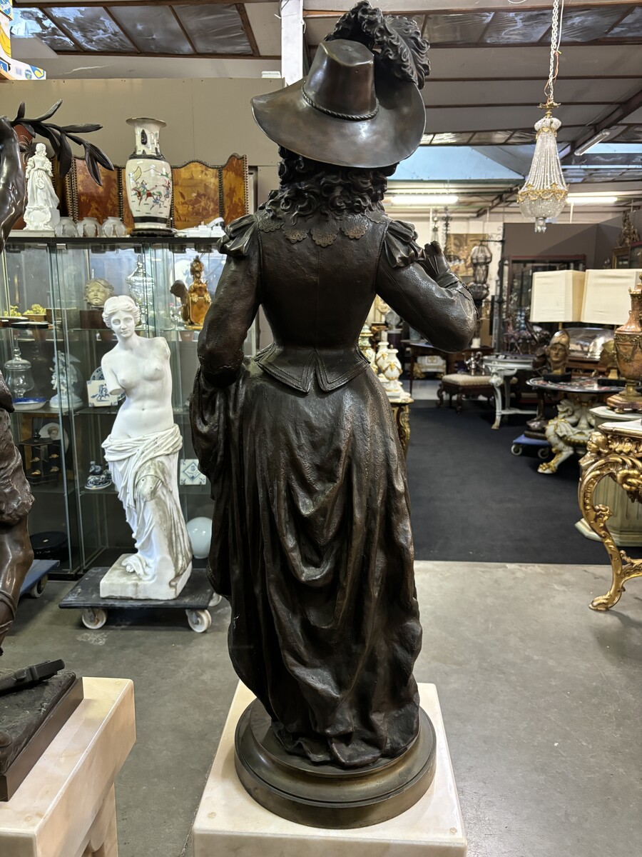 Very large bronze sculpture ‘noble lady ’ 19th century ( 103 cm ). Elegant sculpture of a noble lady with feather hat, signed by Ernest Rancoulet ( French 1870-1915 ). In good condition, with a dent in the base. 