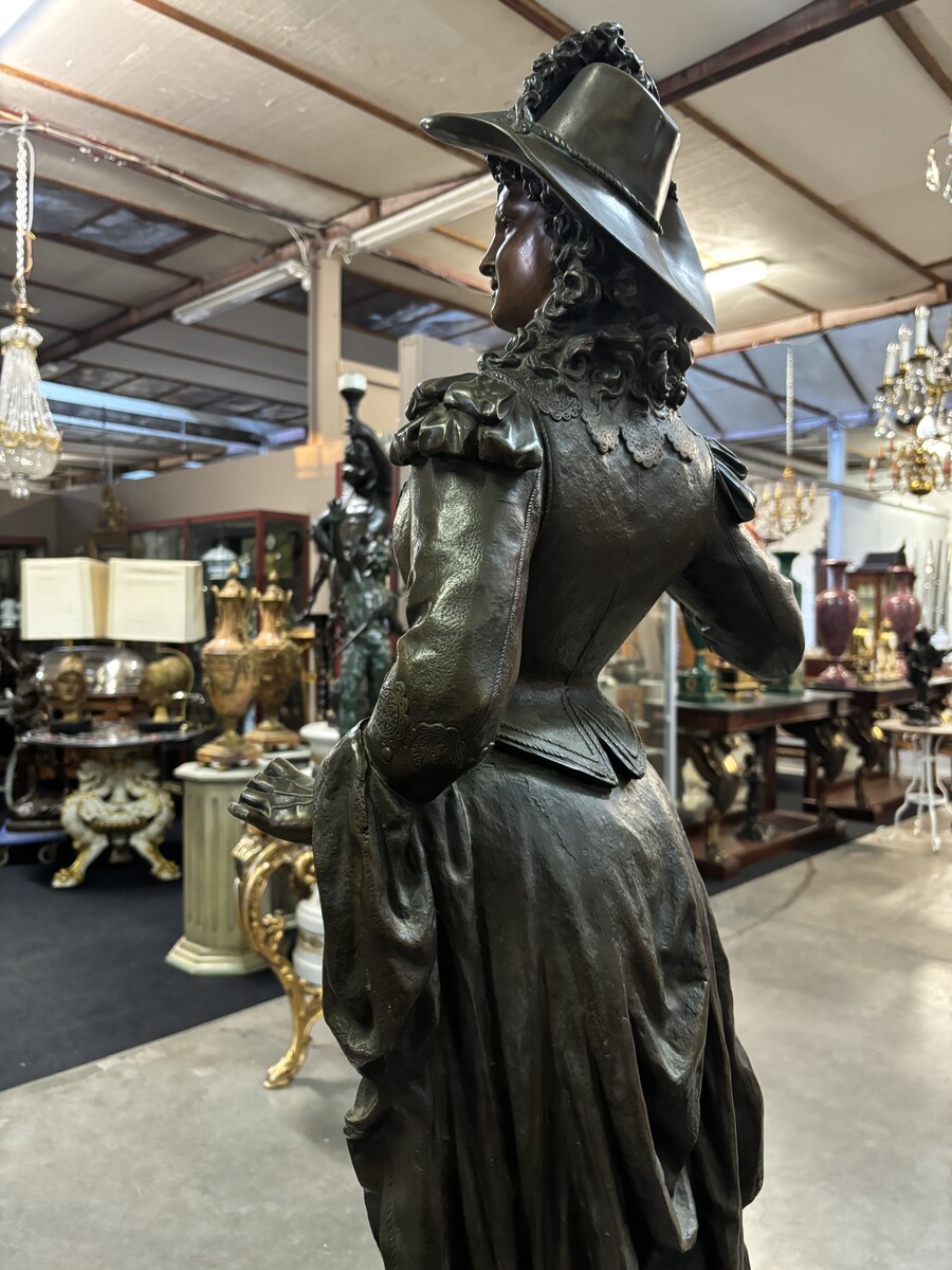 Very large bronze sculpture ‘noble lady ’ 19th century ( 103 cm ). Elegant sculpture of a noble lady with feather hat, signed by Ernest Rancoulet ( French 1870-1915 ). In good condition, with a dent in the base. 