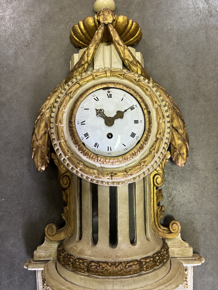 Wall clock on Louis XVI base in painted wood 18th century Decorative cartel in an 18th century wooden case + original dial and wooden base, 19th century movement. Dimensions : Total height: 84 cm Cartel: 56 cm , base: 28 cm Width : 36 cm Depth : 12 cm In 